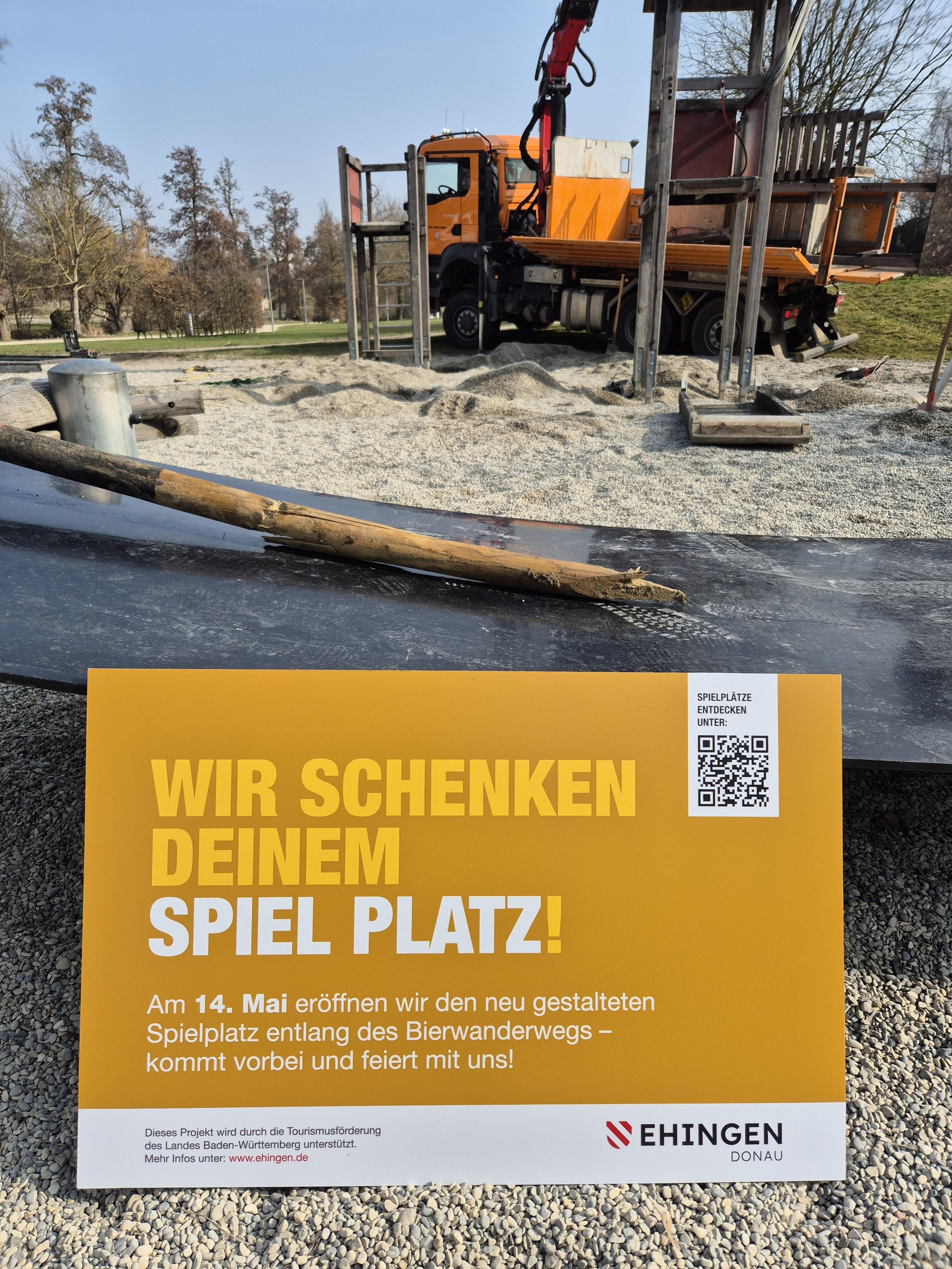Sandkasten auf Spielplatz der umgestaltet wird im Hintergrund Lastwagen mit Kran