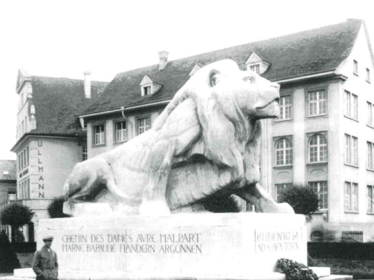 Große Figur eines halb aufgerichteten Löwen auf einem Betonsockel