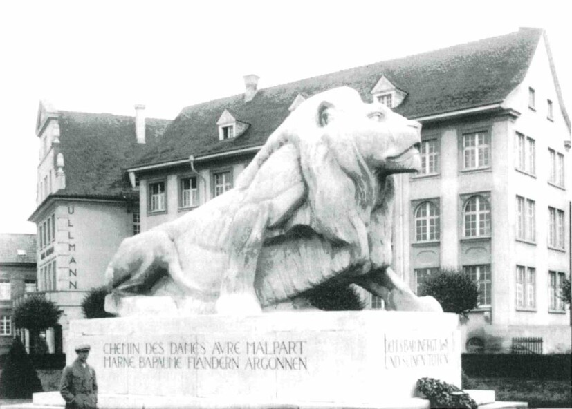 Große Figur eines halb aufgerichteten Löwen auf einem Betonsockel