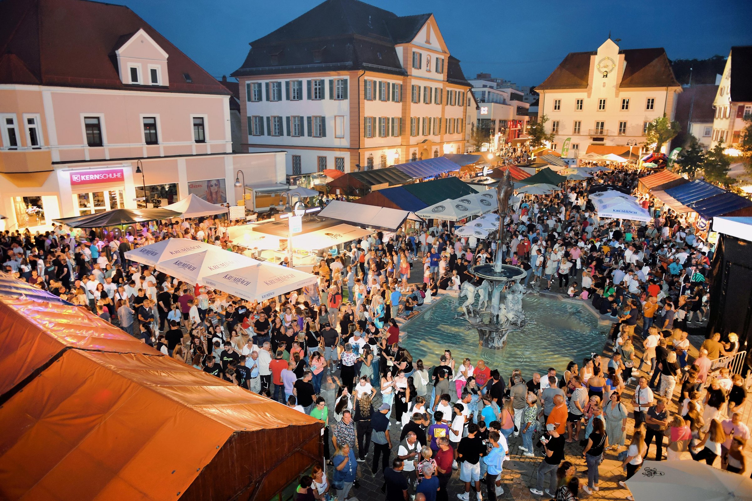 Abendstimmung auf dem Marktplatz, viele Menschen in geselliger Runde.