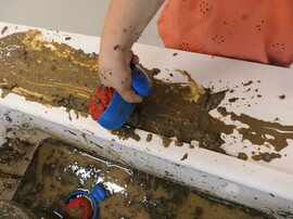 eine Kinderhand beim Matschen fotografiert