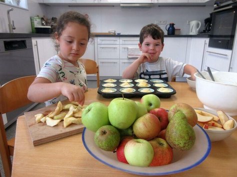 Zwei Kinder backen Apfel Muffins