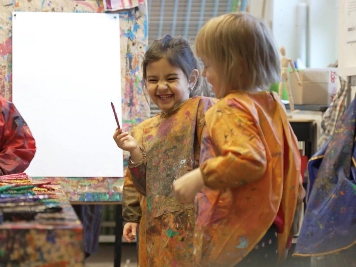 Zwei Mädchen mit Pinsel vor einer Staffelei