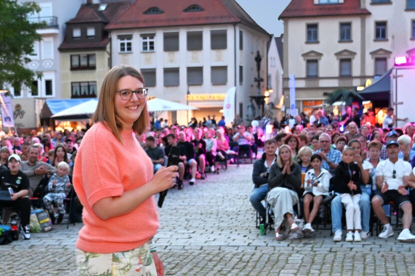 Rabea Christ vom Ehinger Stadtmarketing Foto: Emmenlauer Leiterin des Stadtmarketings mit Mikro in der Hand vor den Zuschauern