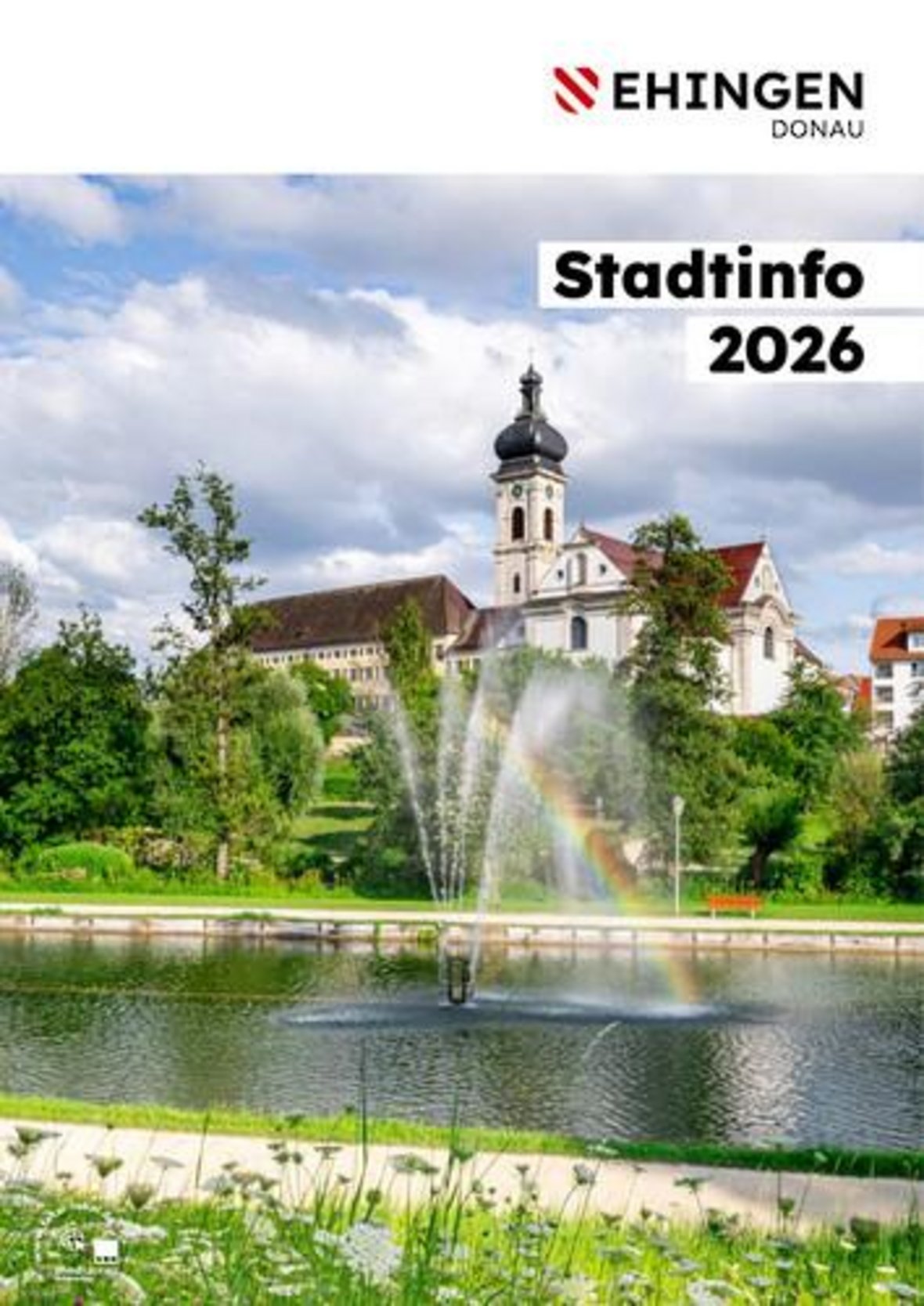 Titelbild der Broschüre zeigt eine Kirche nebst historischem Gebäude im Hintergrund, im Vordergrund befindet sich der Stadtsee mit Fontäne mittig in welcher sich ein Regenbogen spiegelt