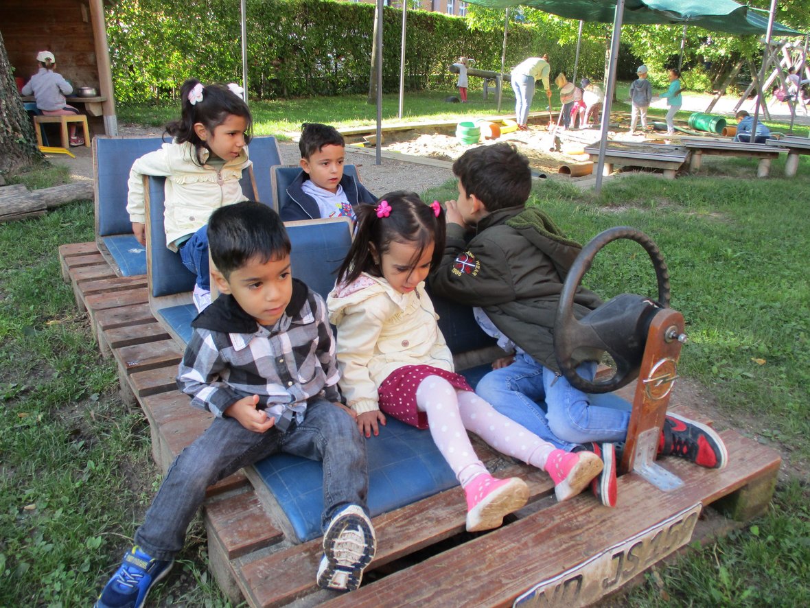 Kinder auf einem Spielgerät im Außenbereich.