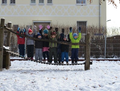 Kinder im Winter im Außenbereich auf einem Spielgerät