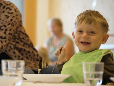 Lachender Junge beim Essen.